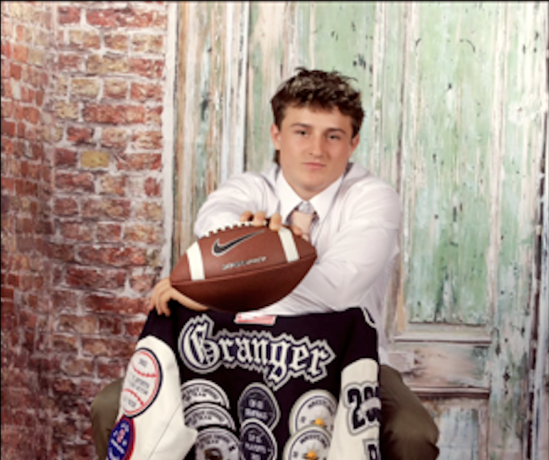 Young person holding football in casual setting.
